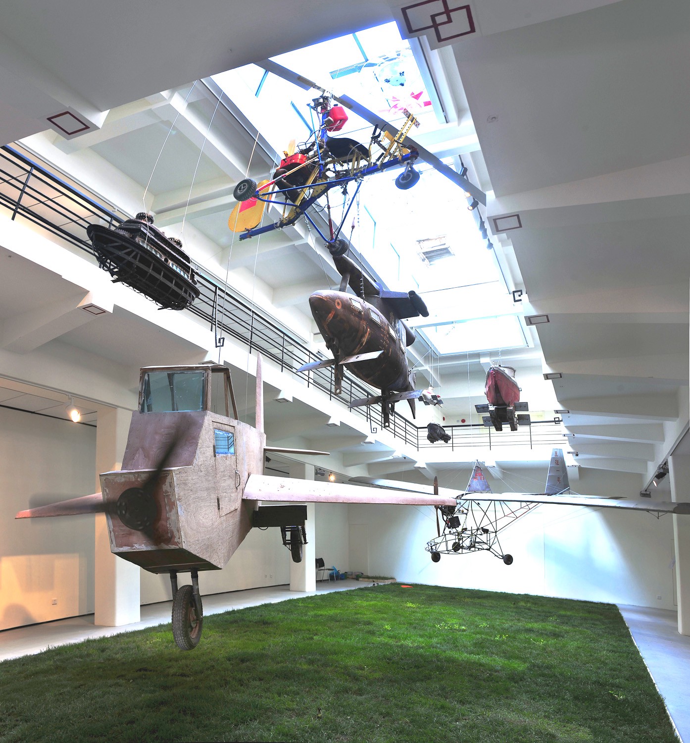 蔡国强，《童话》，2010。草皮、活鸟60只、野花、陈种植的《木飞机》、王强的《王强一号》、李玉明的潜水艇、徐斌的直升机、吴书仔的直升机、杜文达的飞碟。蔡国强策展的「农民达芬奇」中《童话》展览现场,上海外滩美术馆, 2010。林毅摄，蔡工作室提供