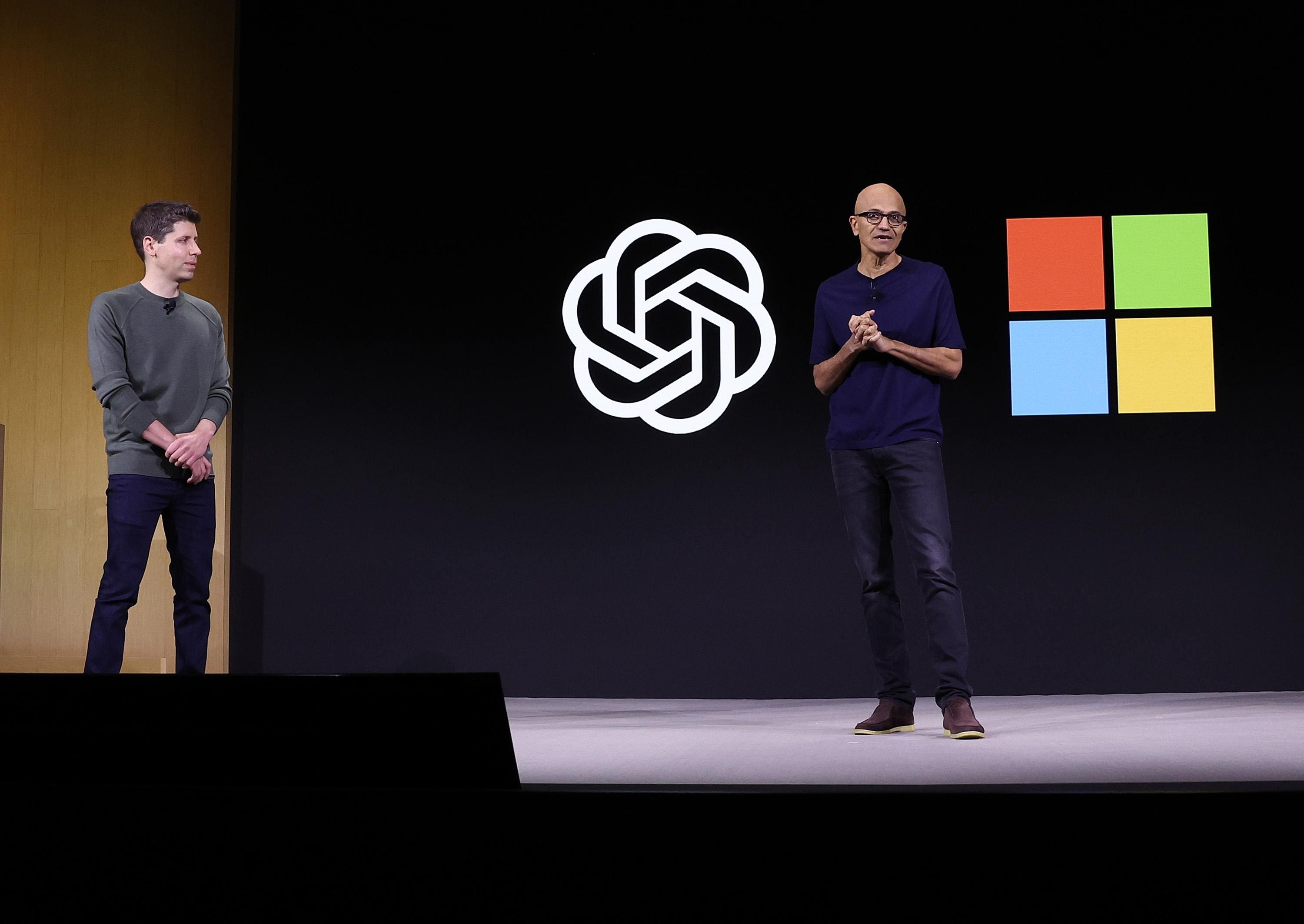 Microsoft CEO Satya Nadella (R) speaks as OpenAI CEO Sam Altman (L) looks on during the OpenAI DevDay