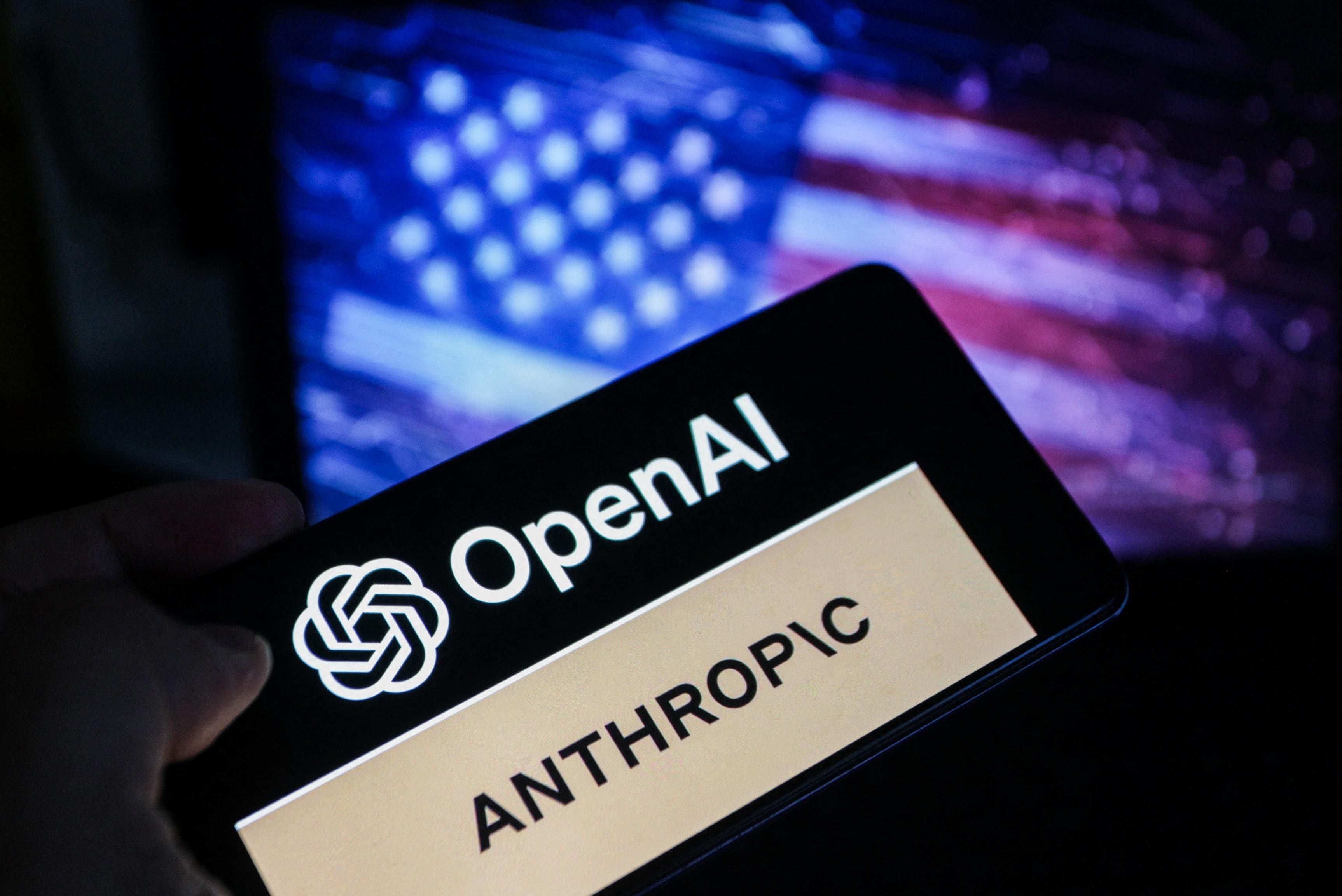 A smartphone screen displays the logos of OpenAI and Anthropic against a blurred backdrop of the American flag.